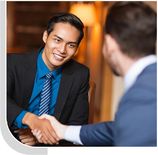 Two men shaking hands in front of a mirror.