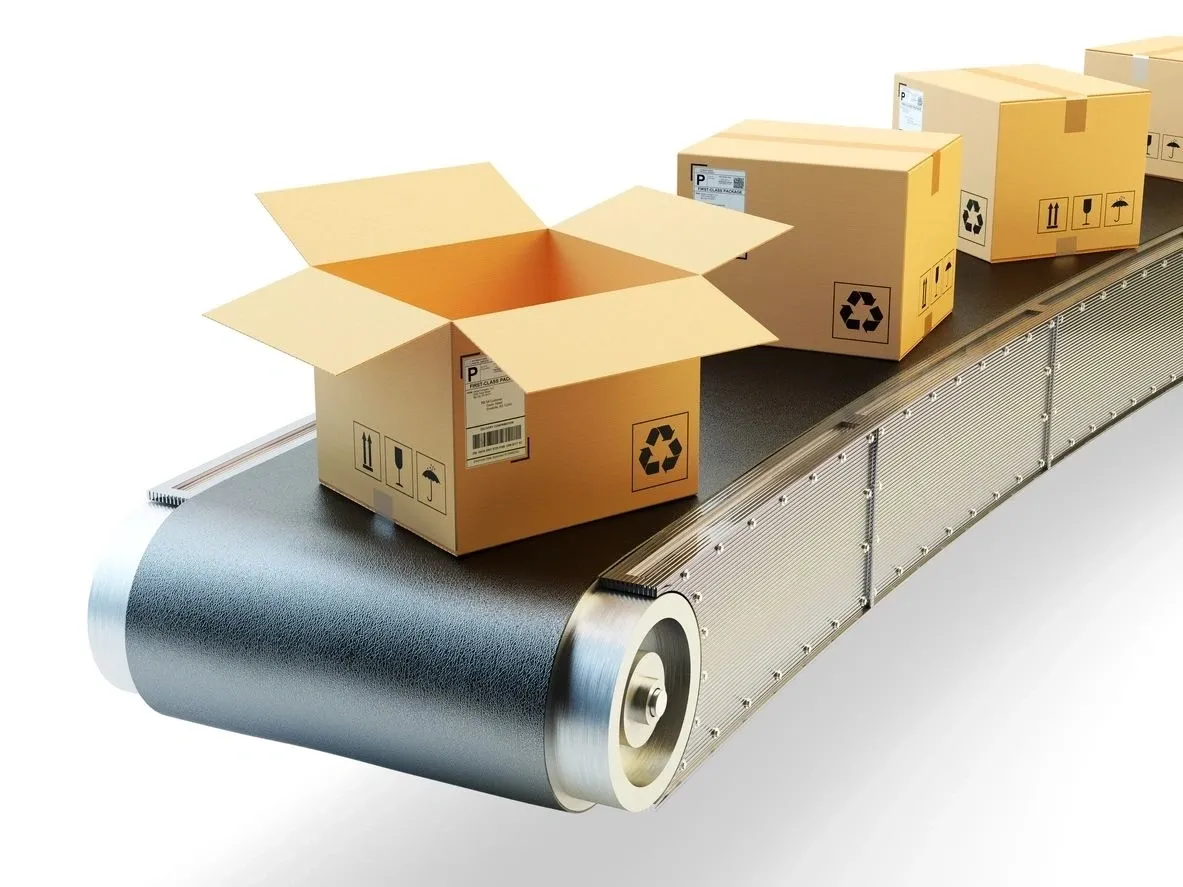 A conveyor belt with three boxes on it.